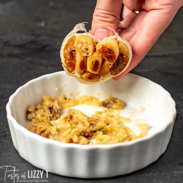 A woman holding roasted garlic