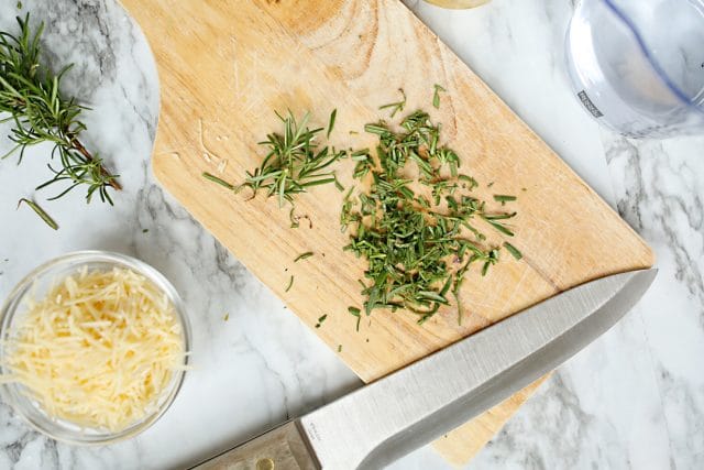 snipped rosemary on a cutting board