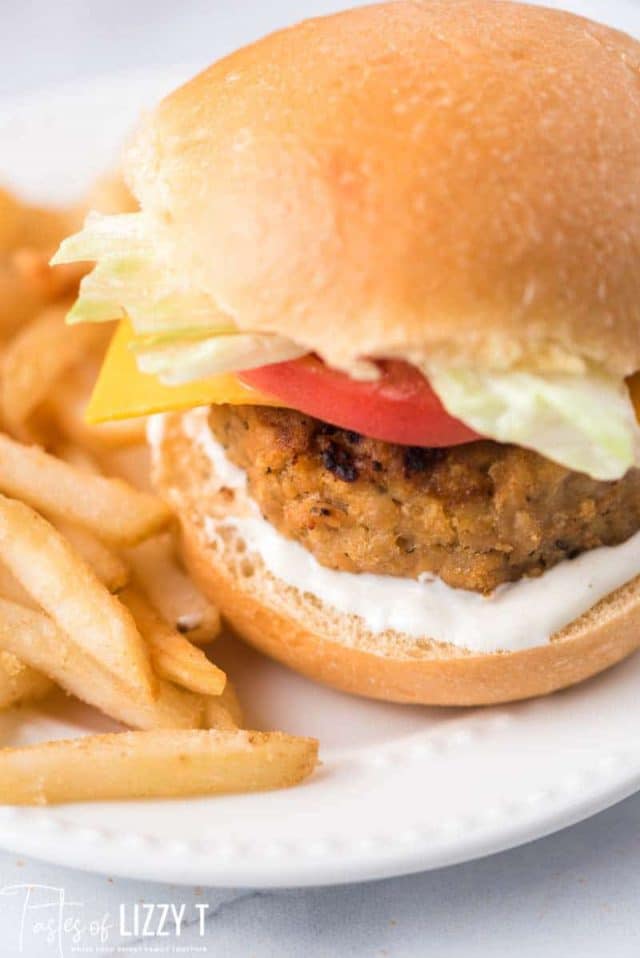 chicken burgers with toppings on a plate with fries