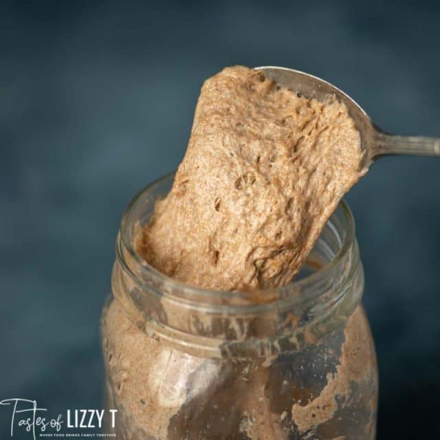 stretchy sourdough starter in a jar and on a spoon