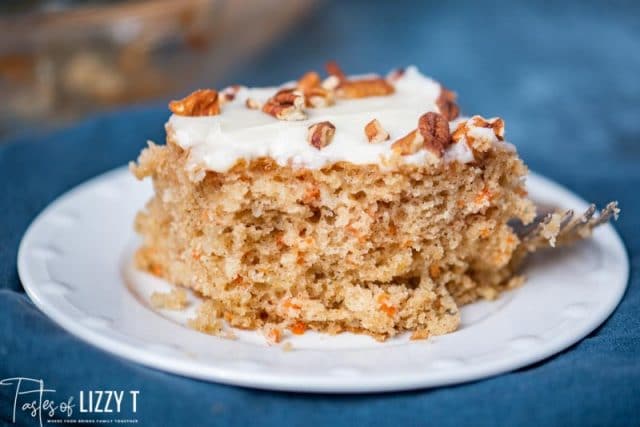 slice of carrot cake on a plate with cream cheese frosting