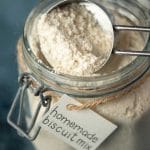 Homemade bisquick in a jar with a measuring cup