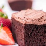 frosted chocolate cake on a plate with strawberries