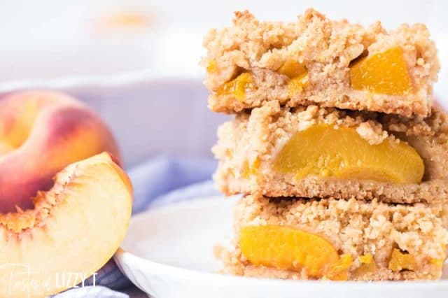 stack of three peach crumb bars on a plate