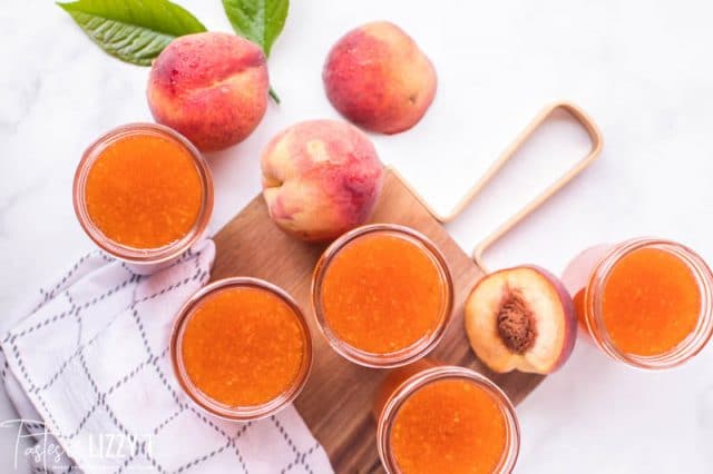 overhead shot of 4 peaches and 5 peach jam jars