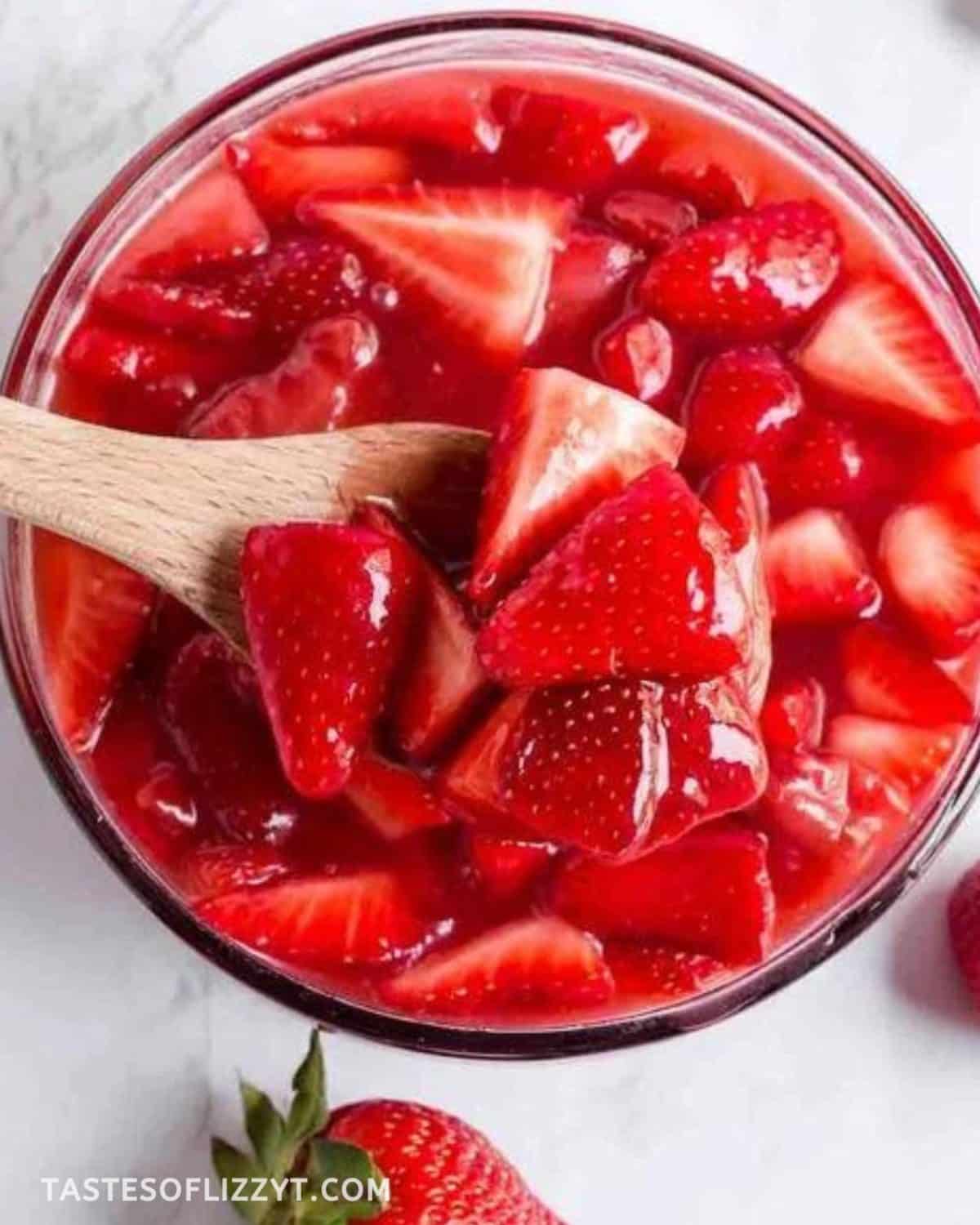 bowl of strawberry sauce with a wooden spoon