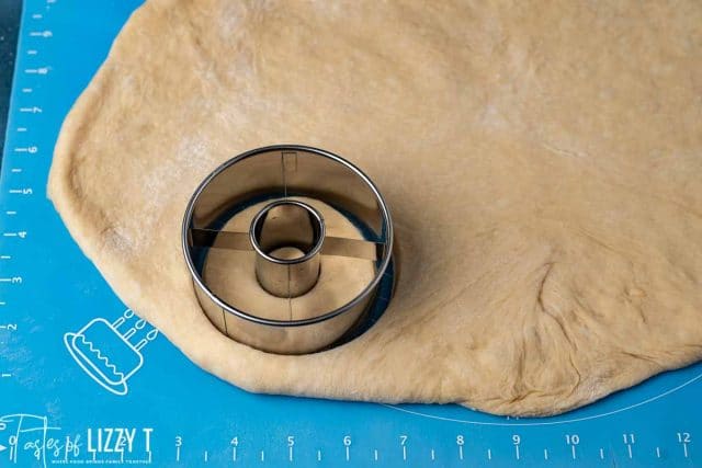 donut cutter on rolled out dough