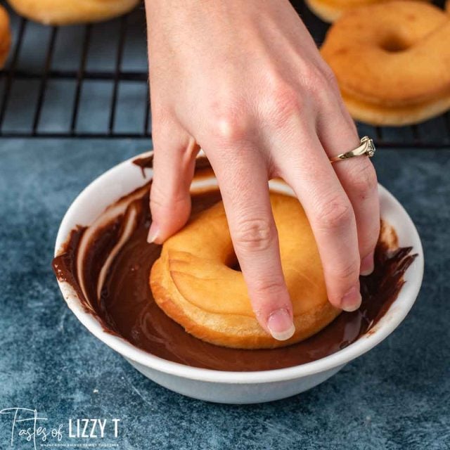 donut dipping in chocolate glaze