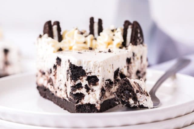 a piece of oreo cheesecake on a plate with a bite out of it