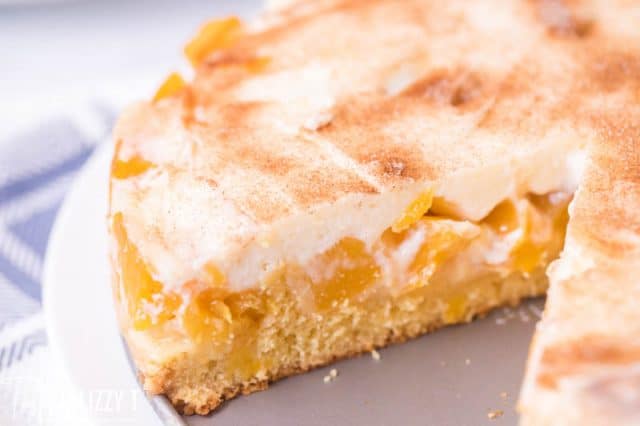 peaches and cream cake with a slice missing