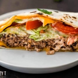 half of a quesadilla burger on a plate