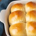 golden brown sourdough rolls in a 9x13 white pan