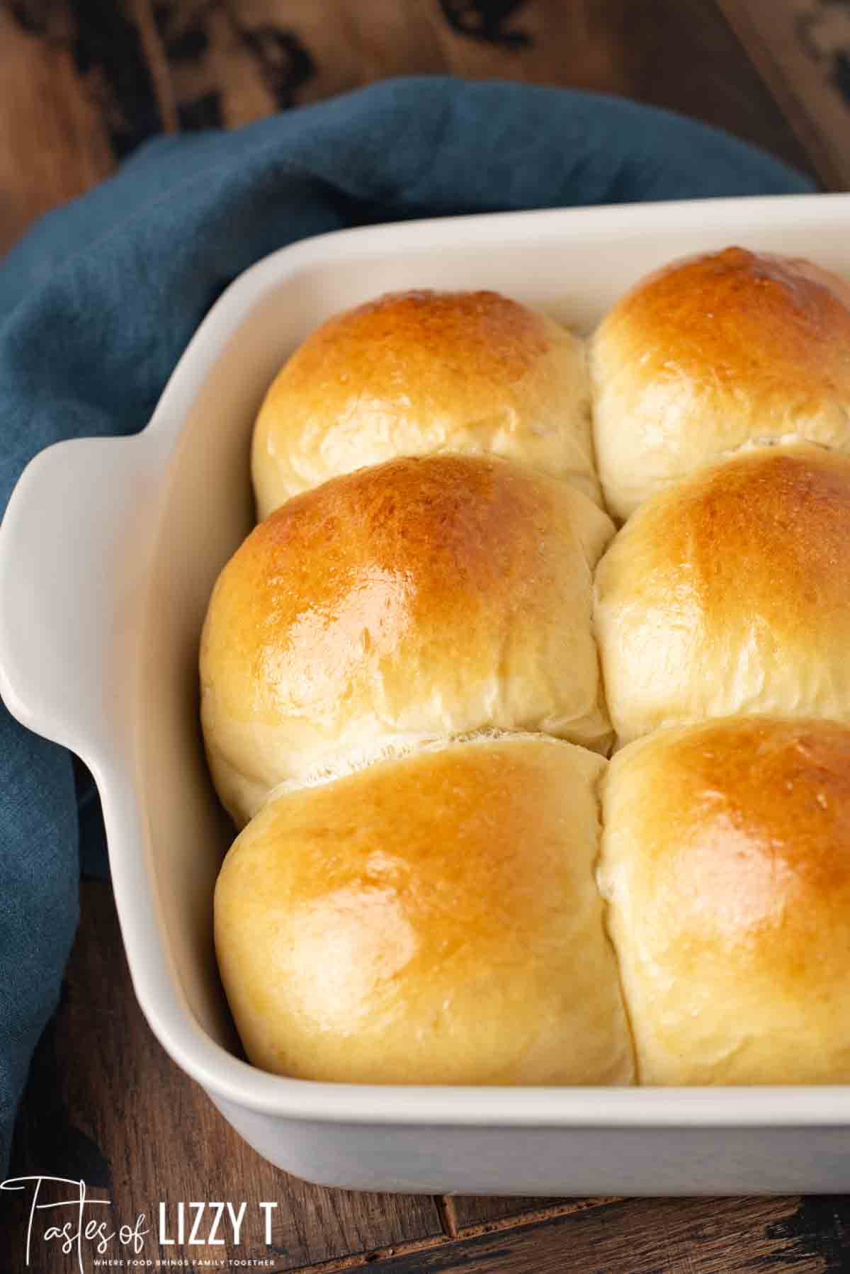 golden brown sourdough rolls in a 9x13 white pan