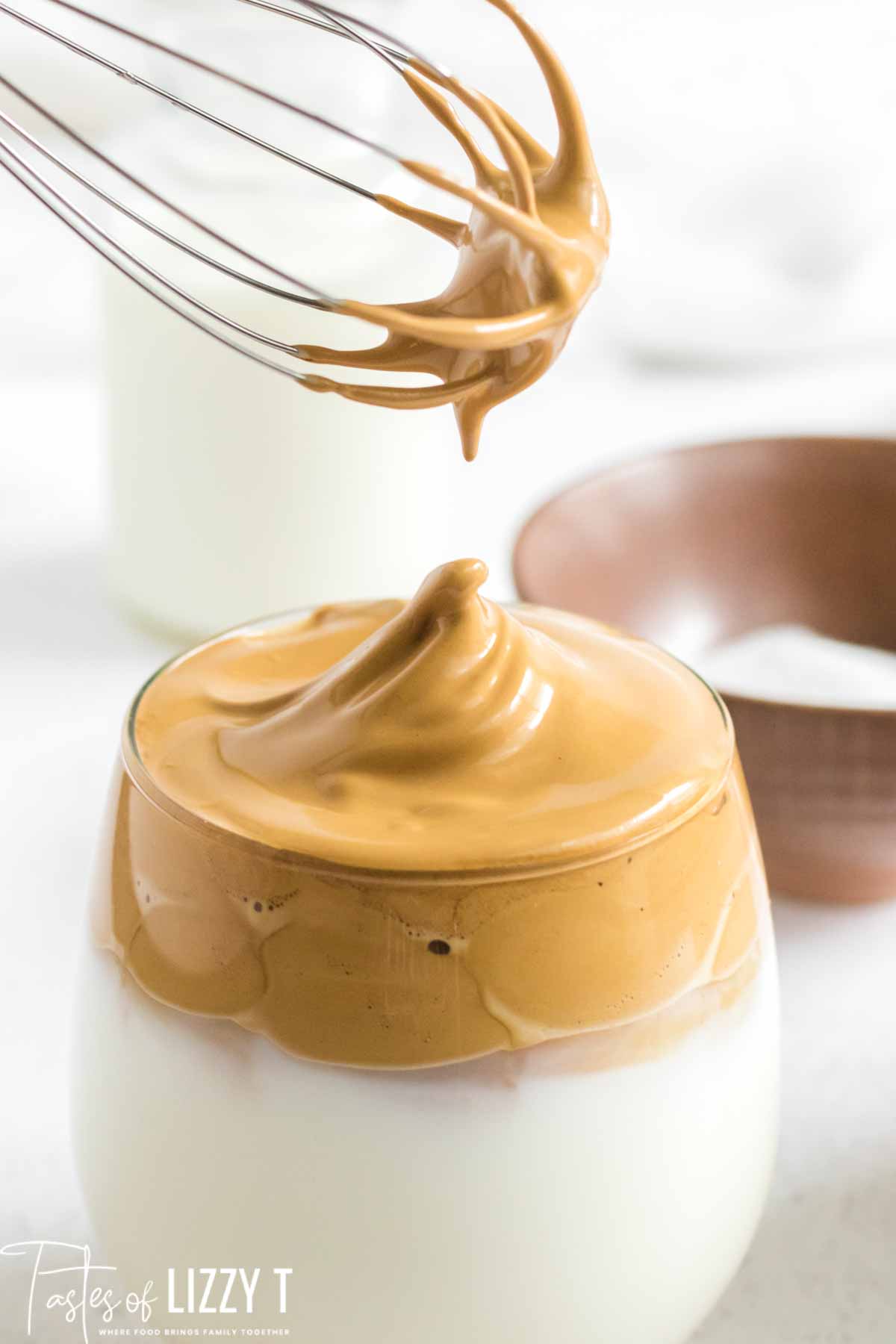 whisk dolloping whipped coffee in mug
