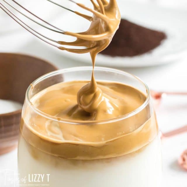 whisk putting frothed coffee in cup