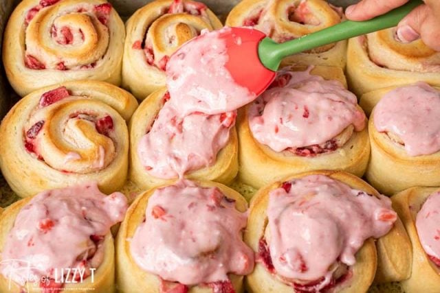 spreading frosting on strawberry rolls