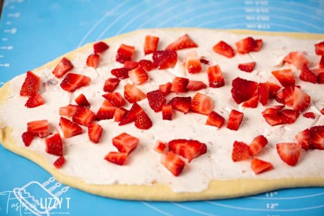 fresh strawberries and cream cheese on dough