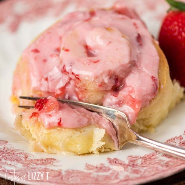 strawberries and cream sweet roll on a plate with a fork
