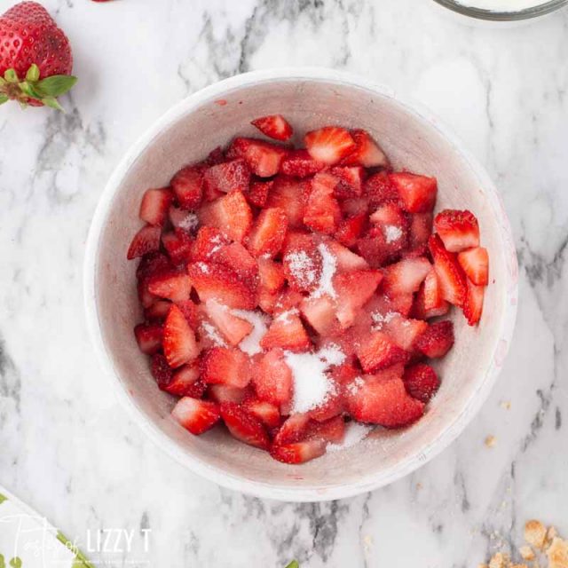 strawberries and sugar in a mixing bowl