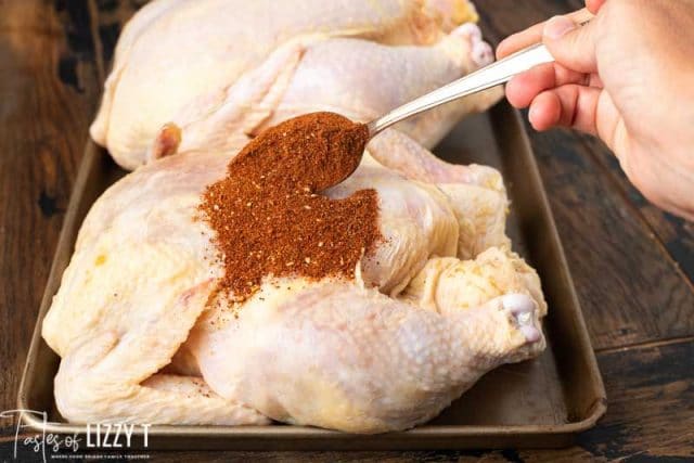 spooning bbq seasoning over chicken