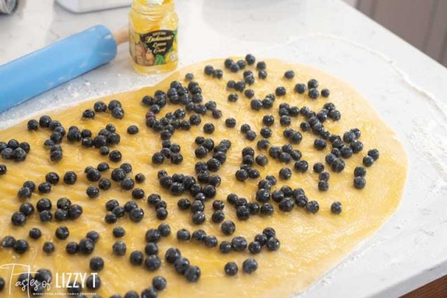 blueberries and lemon curd on sweet roll dough