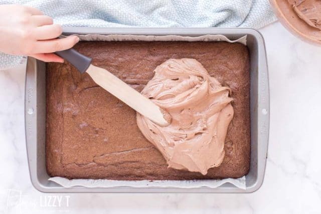 frosting spread over brownies