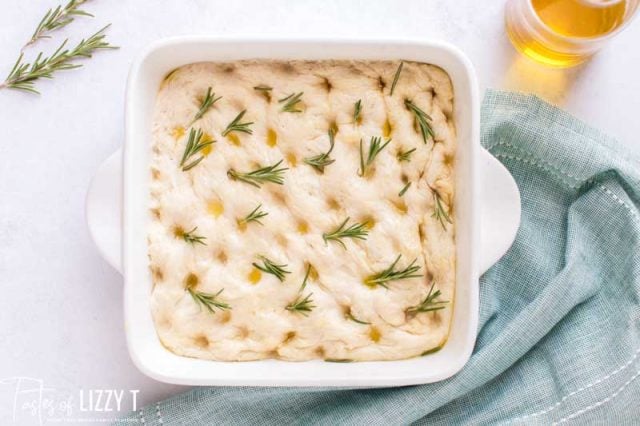 focaccia dough in baking pan with rosemary