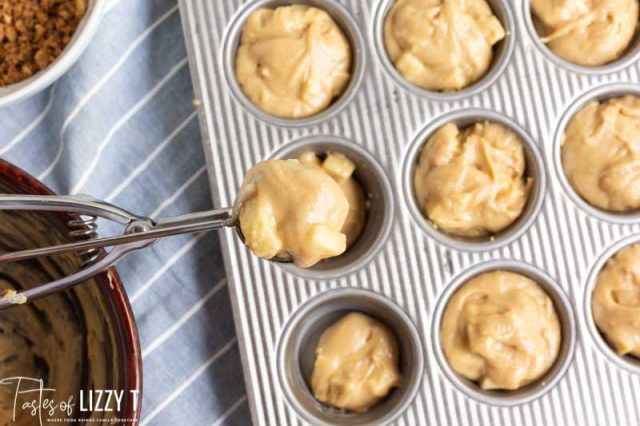 scooping muffin batter into pan