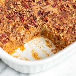 pecan pumpkin dump cake in a pan with one slice out