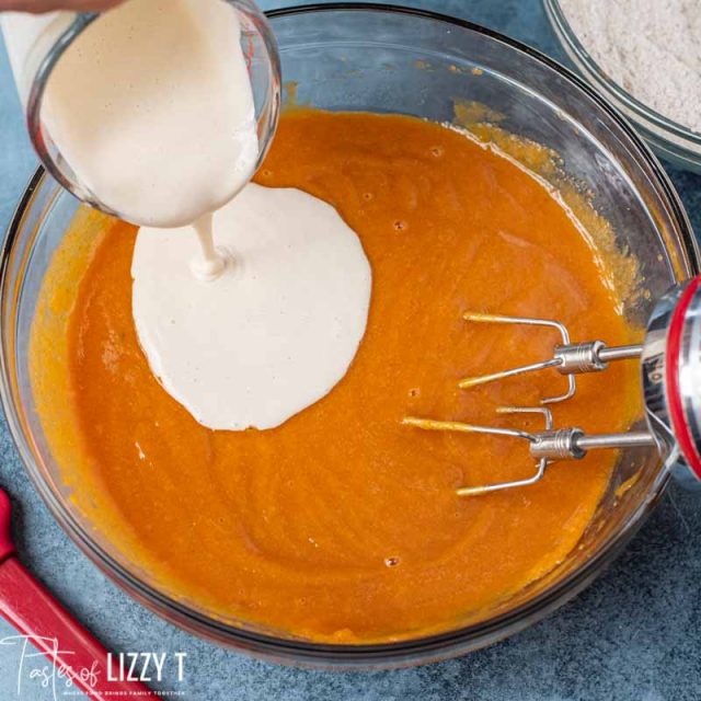 pouring sourdough into pumpkin bread batter