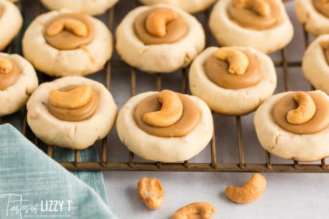 caramel filled cashew thumbprint cookies on a wire rack