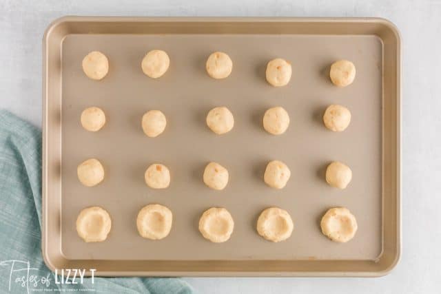 unbaked cashew thumbprint cookies on a pan