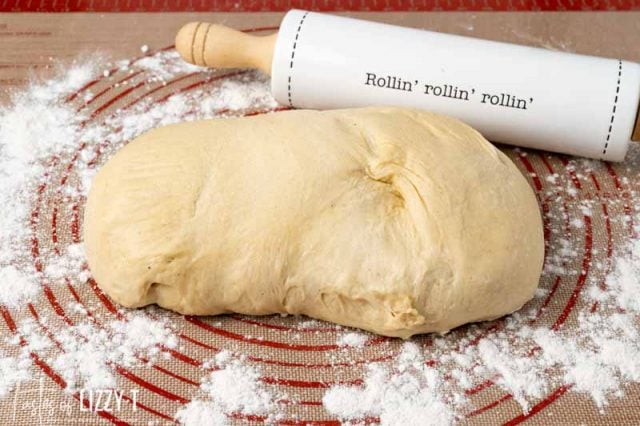 ball of dough and rolling pin on floured mat