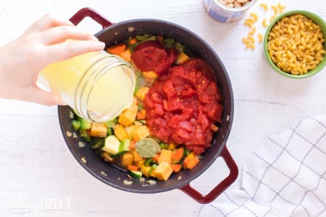 pouring broth into soup pot
