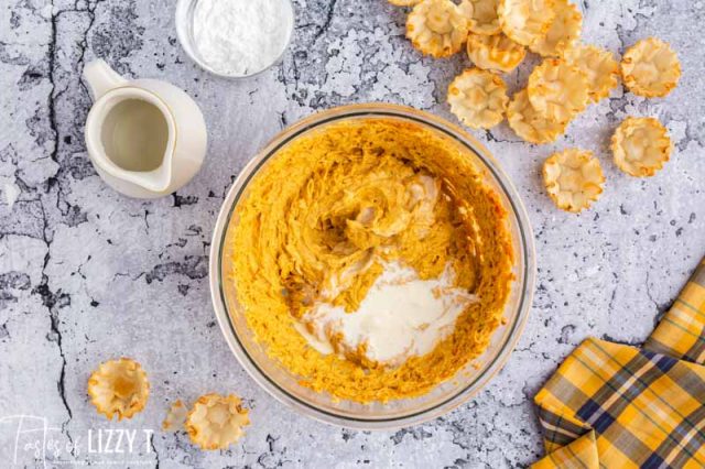 adding cream to pumpkin filling