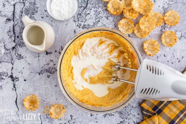 adding cream to pumpkin cheesecake batter