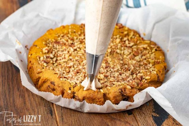 piping frosting on pumpkin pecan cookie pie