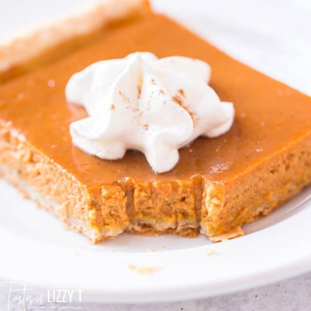 pumpkin pie on a plate with a bite out