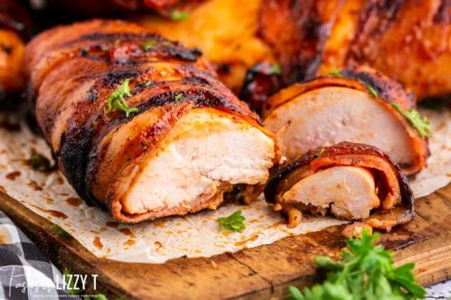 bacon wrapped bbq chicken breast sliced on cutting board