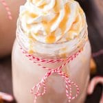 closeup of glass of caramel hot chocolate with whipped cream