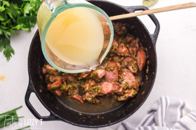 pouring chicken stock in stockpot