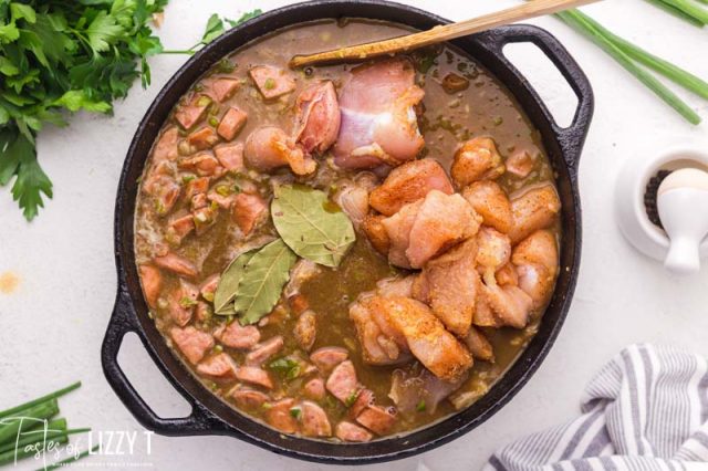 chicken and sausage cooking in a pot of gumbo