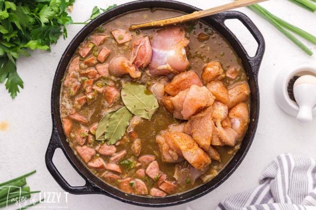 chicken and sausage cooking in a pot of gumbo