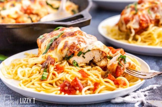 chicken breast over a plate of spaghetti