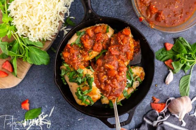 tomato sauce over chicken in a skillet