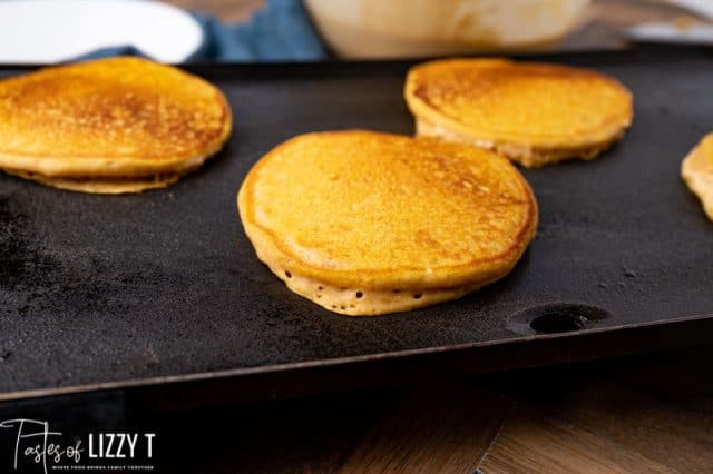 pancakes cooking on a griddle