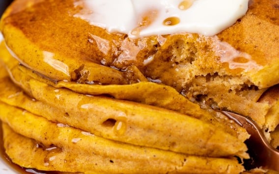 stack of pancakes with a fork cutting in