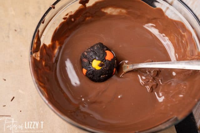 dipping a truffle in melted chocolate