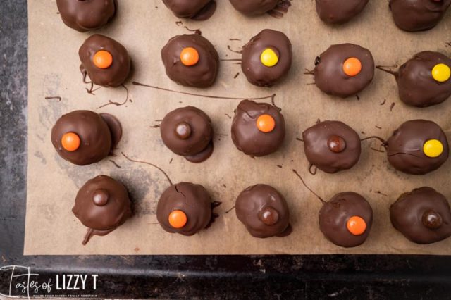 chocolate covered truffles with reese's pieces on a baking sheet