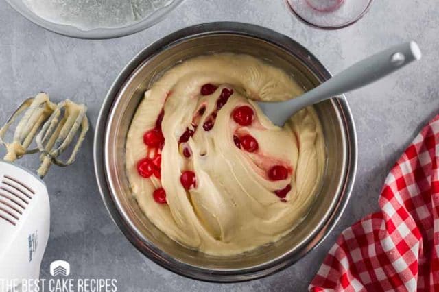 cake batter with cherries in a bowl